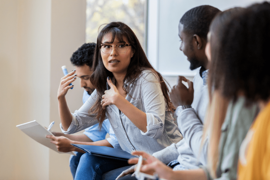 Woman talking with group gesturing forward
